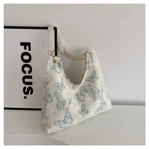 Détail du sac cabas en tweed blanc avec motifs papillon bleus et bords à franges