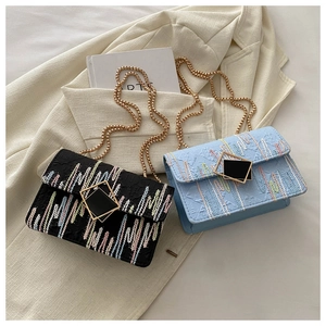 Detail bunter strukturierter Kettentaschen mit goldenen Schnallen auf weißem Blazer