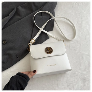 Detail of white leather crossbody bag featuring vintage bear embossed metal clasp