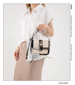 Detail showing woven straw texture and leather trim of the stylish crossbody flap bag
