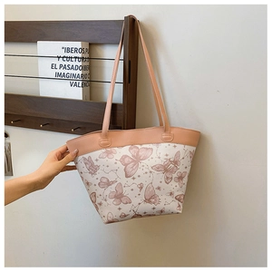 Detail of a large tote bag featuring vintage butterfly prints on a light pink surface