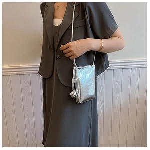 Detail of silver metallic mini crossbody phone bag with knot decorative strap