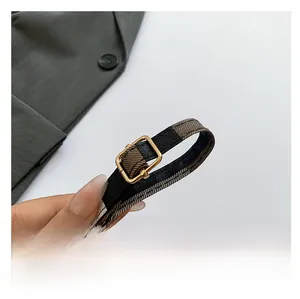 Adjustable brown and black check replacement strap with gold metal buckle detail