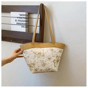Detailed close-up of butterfly print tote bag on a wooden stand in a lifestyle setting