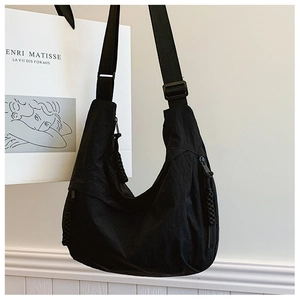 Detail of black nylon crescent bag with wide strap and woven cord zipper puller