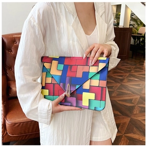 Macro shot of colorful geometric block print clutch with golden envelope lock buckle