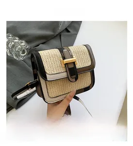 Detail of woven straw crossbody bag with gold H-clasp and leather trim detail