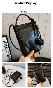Detail of black cross-body phone bag with knot decorative strap and oil wax texture