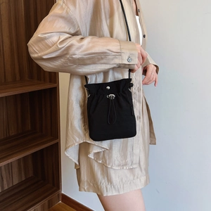 Minimalist black nylon drawstring crossbody bag with silver hardware for daily casual use