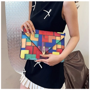 Detailed view of women's envelope clutch with colorful geometric blocks and gold buckle