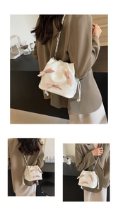 Vues détaillées d'un sac seau blanc avec des nœuds roses et une bandoulière en chaîne
