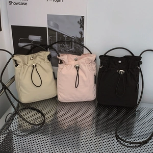 Minimalist nylon drawstring bucket bags in cream, pink, and black colors for women