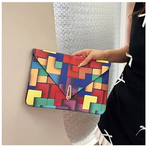 Detailed view of women's envelope clutch with colorful geometric blocks and gold lock