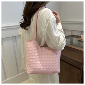 Close-up of pink woven texture tote bag featuring intricate leather craftsmanship detail