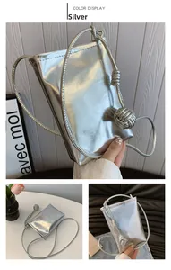 Detailed view of silver crossbody bag with metallic finish and decorative spherical knot