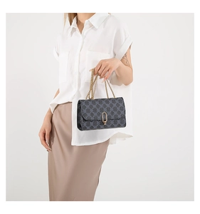 Detail of vintage floral pattern shoulder bag with gold chain strap and metal clasp