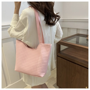 Close-up detail of the pink woven texture and handle of this large shoulder tote bag