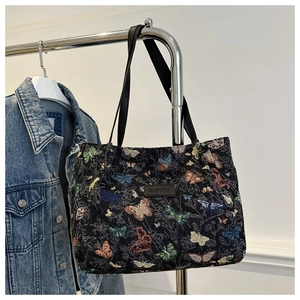 Detail view of butterfly jacquard tote bag with leather straps and logo patch