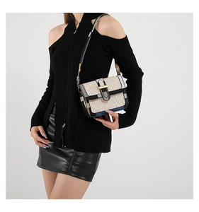 Close-up of woven crossbody bag with geometric color blocks and gold buckle detail
