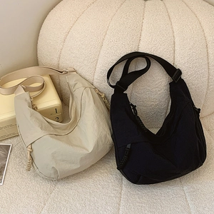 Minimalist nylon crescent crossbody bag in black and off-white with adjustable strap