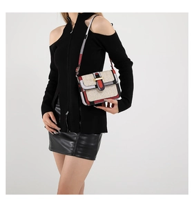 Detail of a minimalist square crossbody bag featuring woven texture and tricolor accents