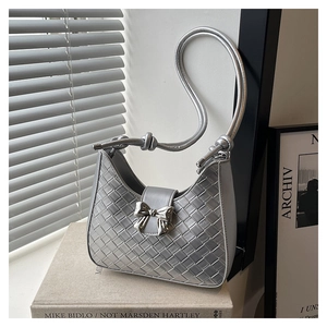 Detail of silver woven hobo bag featuring metallic bow buckle and knotted handle design