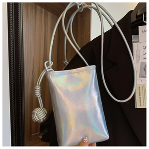 Close-up of holographic crossbody phone bag with iridescent finish and woven ball detail