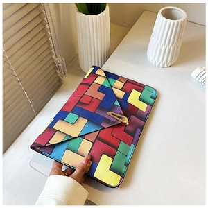 Macro shot of colorful geometric contrast clutch with gold hardware and cross texture