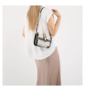 Detail of woven crossbody bag with houndstooth flap and golden metal buckle closure