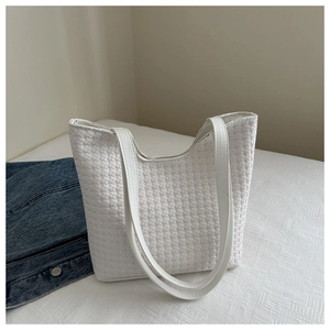 Detail of white woven texture on leather tote bag with thin shoulder straps