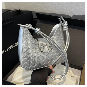 Detail of silver woven leather shoulder bag with metallic finish and bow accessory