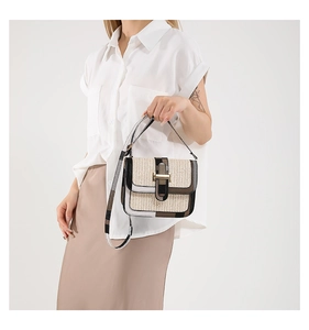 Detail of a casual woven square bag with leather trim and stylish plaid crossbody strap
