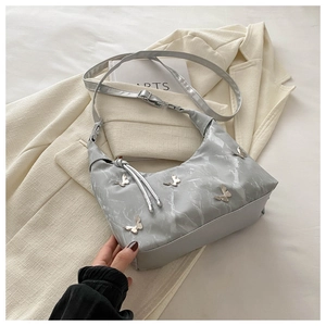 Détail du sac cabas motif marbre avec papillons argentés et élément de nœud tissé