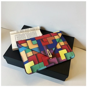 Detailed view of color-block envelope bag with geometric patterns and golden metal clasp