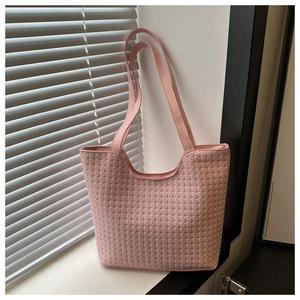 Close-up of pink woven tote bag showing detailed texture and parallel shoulder straps