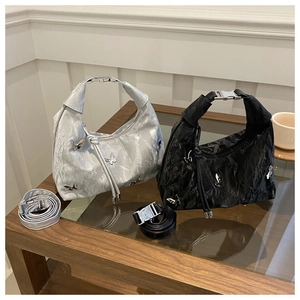 Détail de sacs cabas plissés tendance avec papillon argenté en noir et gris argenté