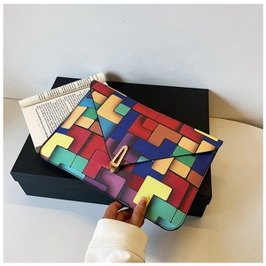 Detail of colorful geometric pattern envelope clutch bag with golden metal buckle
