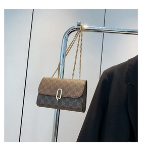 Detail of vintage flap bag showing geometric patterns and golden U-shaped buckle