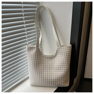 Close-up of white woven tote bag with checkered pattern and durable double straps