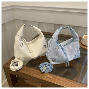 Vue détaillée des sacs bohèmes avec ornements papillons et texture plissée élégante