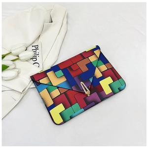 Detail of color-block envelope clutch featuring geometric patterns and a gold metal lock