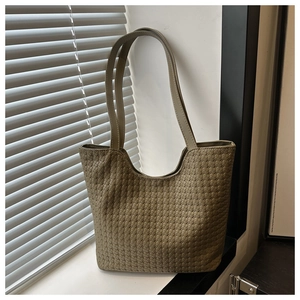 Macro detail of olive green woven leather texture on a minimalist large tote bag