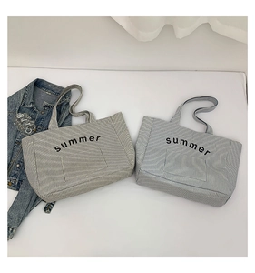 Détail de sacs cabas en toile rayée avec broderie summer et larges bandoulières