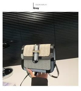Detail of woven straw crossbody bag with grey checkered trim and gold metal clasp