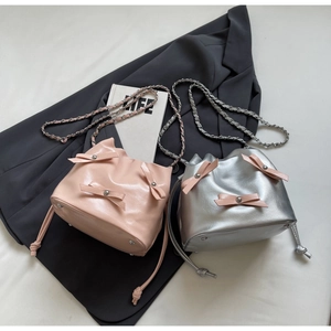 Détails de sacs seaux rose et argent avec nœuds décoratifs et bandoulières en chaîne
