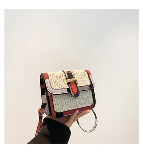 Detailed shot of woven crossbody bag showing natural straw texture and color-block trim