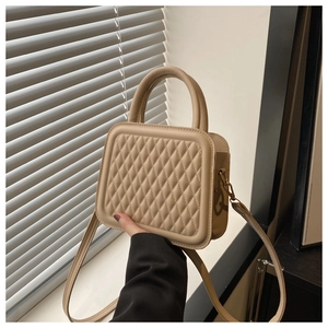 Close-up of beige quilted crossbody bag with circular handle and elegant leather texture