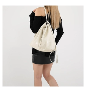 Close-up of cream leather bucket bag with embossed T logo and drawstring closure details