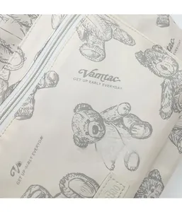 Detail shot of the beige fabric texture with teddy bear print and sturdy white zipper