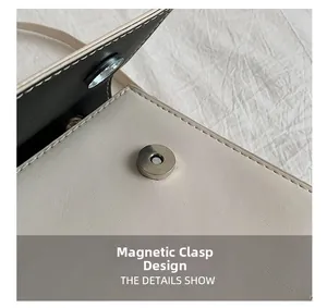 Détail du fermoir magnétique sur le sac à main bicolore beige et noir minimaliste